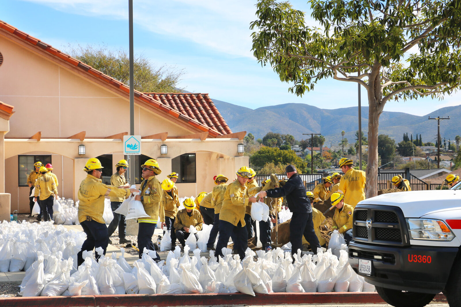 firefighters standing in front of a row of bags with supplies